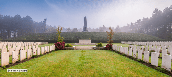 Overzichtsbeeld van een WO I‑begraafplaats met witte graven en een herdenkingsmonument