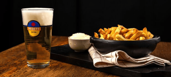 frietjes en Vedett bier op een houten tafel frietjes en Vedett bier op een houten tafel