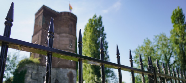 Zicht op de Graventoren van Rupelmonde achter een smeedijzeren hek. De toren verwijst naar de geschiedenis van het voormalige Gravenkasteel. Zicht op de Graventoren van Rupelmonde achter een smeedijzeren hek. De toren verwijst naar de geschiedenis van het voormalige Gravenkasteel.